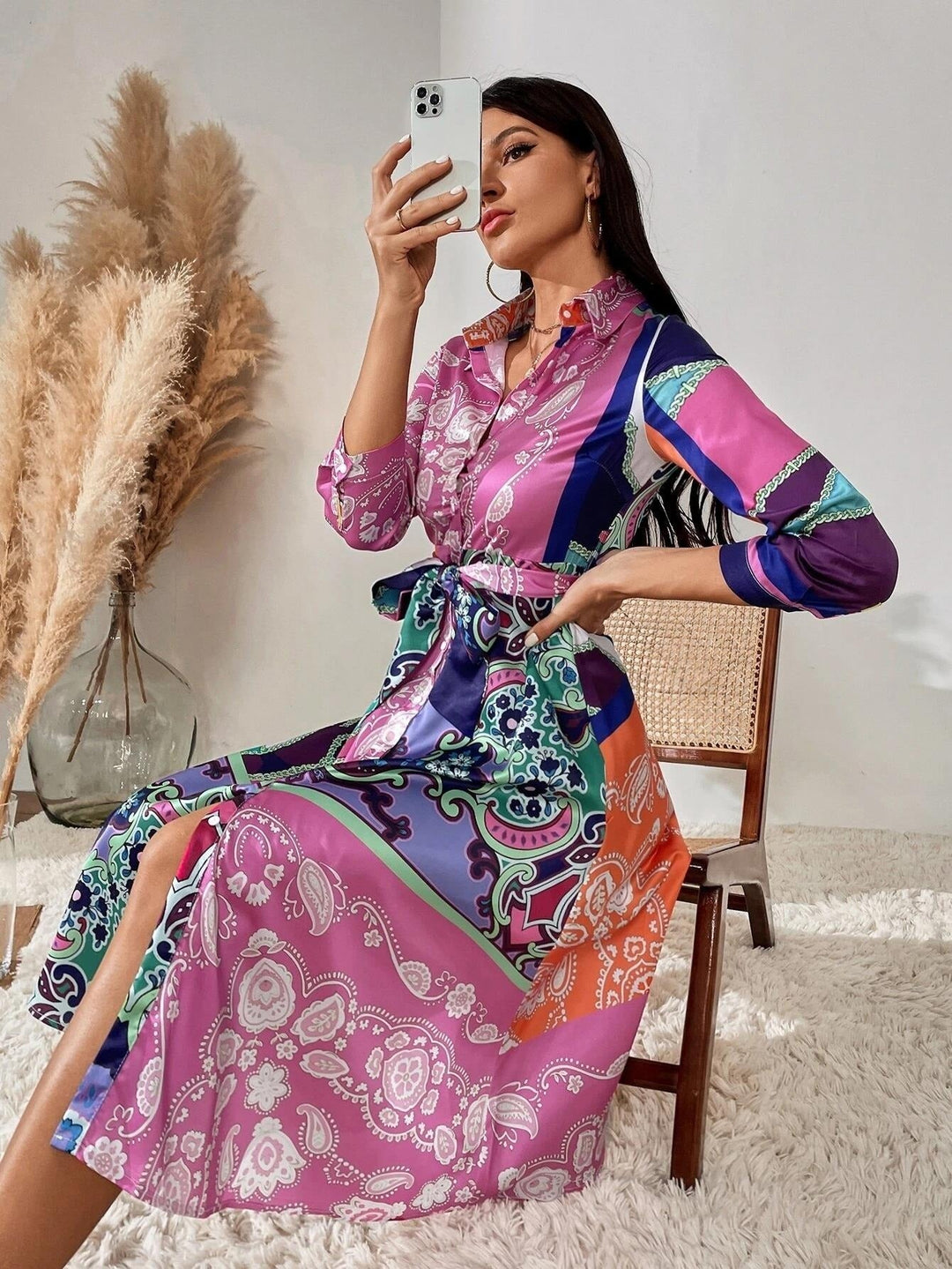 Bakre vy av den mönstrade kvinnors skjortklänning med bälte, visar den snygga passformen.