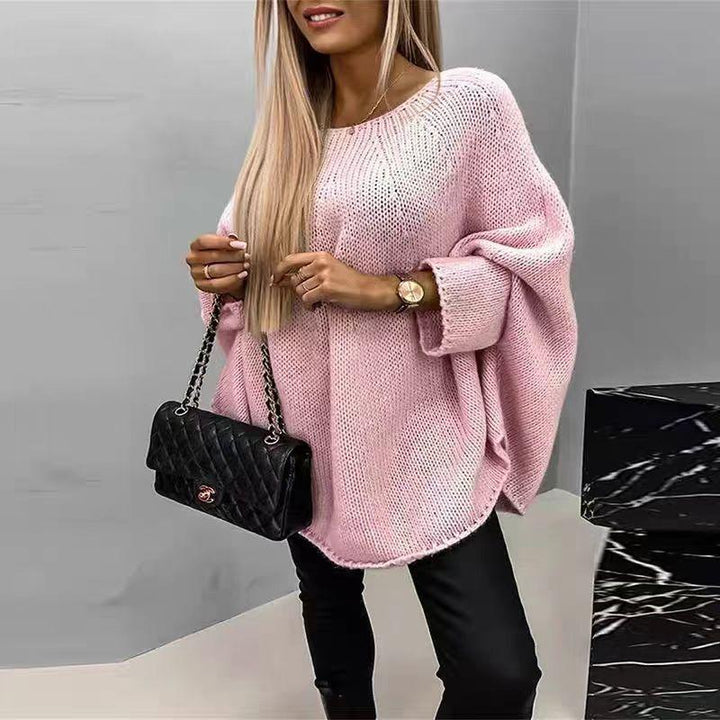 Kvinna bär stilren oversized cape-tröja med batwing-ärmar. En mångsidig tröja för både avslappnad och modern look.
