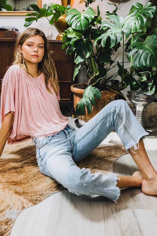 Kvinnomodel bär bekväma raka jeans med hög midja i ljus tvätt, idealiska för sommaren.