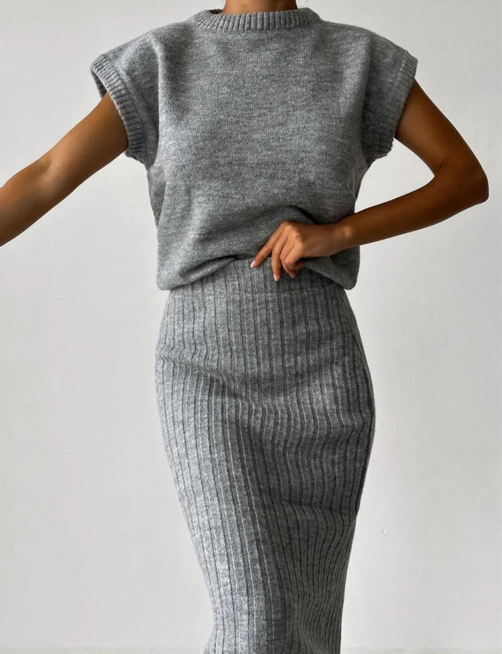 Kvinna sittande i ärmlöst set, elegant och bekvämt för både vardags- och festkläder.