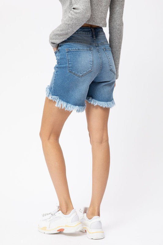 Stilrena kvinnors shorts med hög midja och dynamisk hi-low-fåll i medium denim för en avslappnad look.