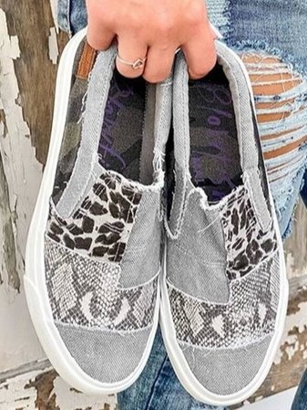 Kvinnors bekväma slip-on skor med leopardmönster i en modern design, sedda från sidan.