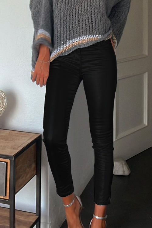 Detaljbild av de figurnära konstläderleggingsen med fickor, visar den släta texturen och sömmarna, en modeaccessoar.