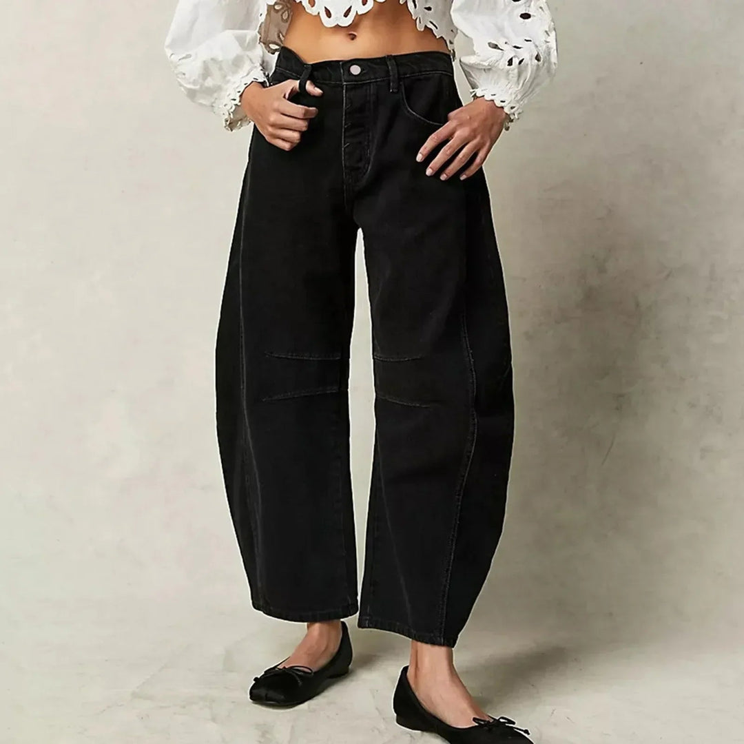 Modell bär utsvängda jeans med låg midja, visar hur de faller och den smickrande silhuetten.