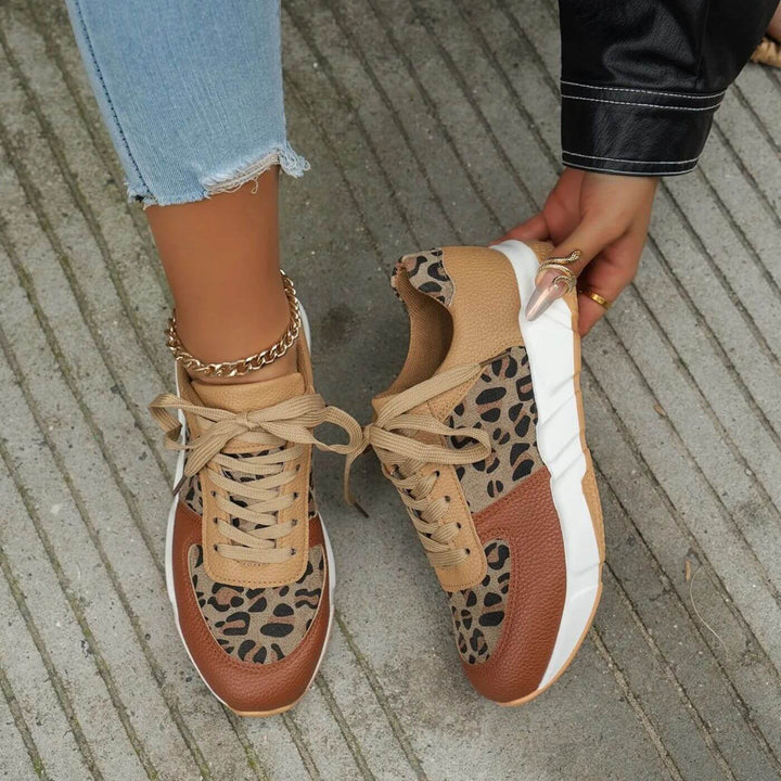 Närbild på kvinnors leopardmönstrade sneakers. Trendiga festskor med detaljerat mönster för en stilsäker look.