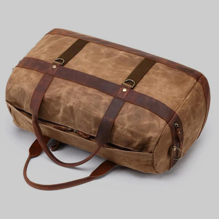 Elegant tvåfärgad duffelväska för kvinnor, vaxad canvas med läderdetaljer för stil och funktion.