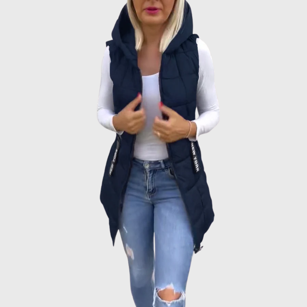 Kvinnors vadderad väst-kappa med huva. Ärmlös, quiltad och modern streetwear-look för kalla dagar.