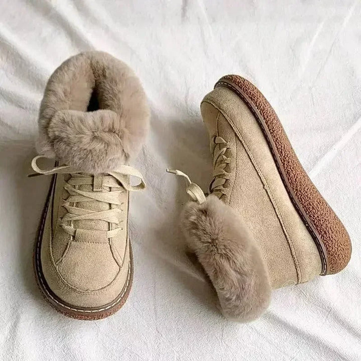 Närbild av beige ankelkängor i mockaliknande material. Varma och stilrena vinterskor med snörning.