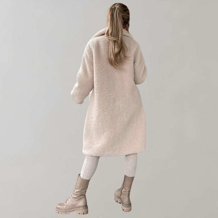 Elegant lång damkappa, klassisk design med smickrande snitt. Perfekt för vardag och fest.