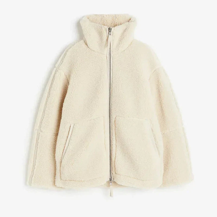 Lång mysig dam teddyjacka i beige med lös passform, perfekt som höst- eller vinterjacka.