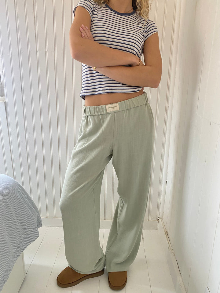 Närbild på tygstrukturen av de casual blå dambyxorna med elastisk midja och raka ben.