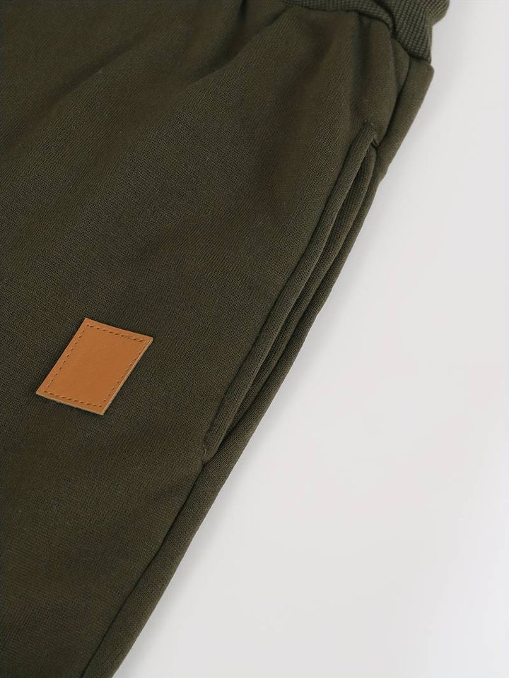Enkla neutrala dragskobyxor för herrar, löst sittande. Lätta att matcha för en ledig look.
