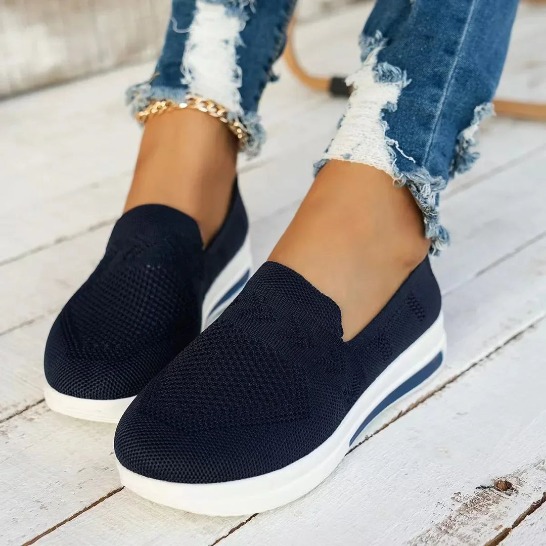 Närbild av andningsbart meshmaterial på kvinnors sneakers. Ger svalka och komfort för sommardagar.