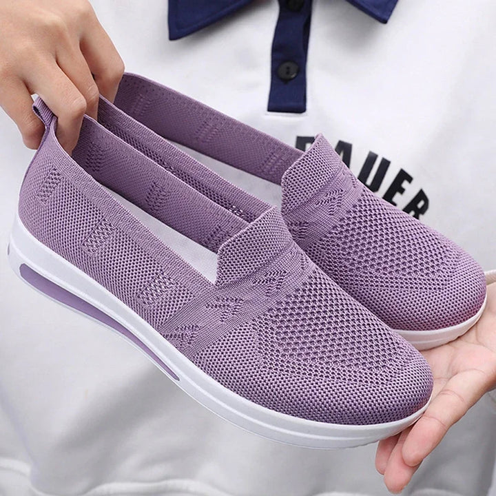 Kvinna bär moderna, lätta sneakers utomhus. Perfekta komfortskor för dagliga äventyr.