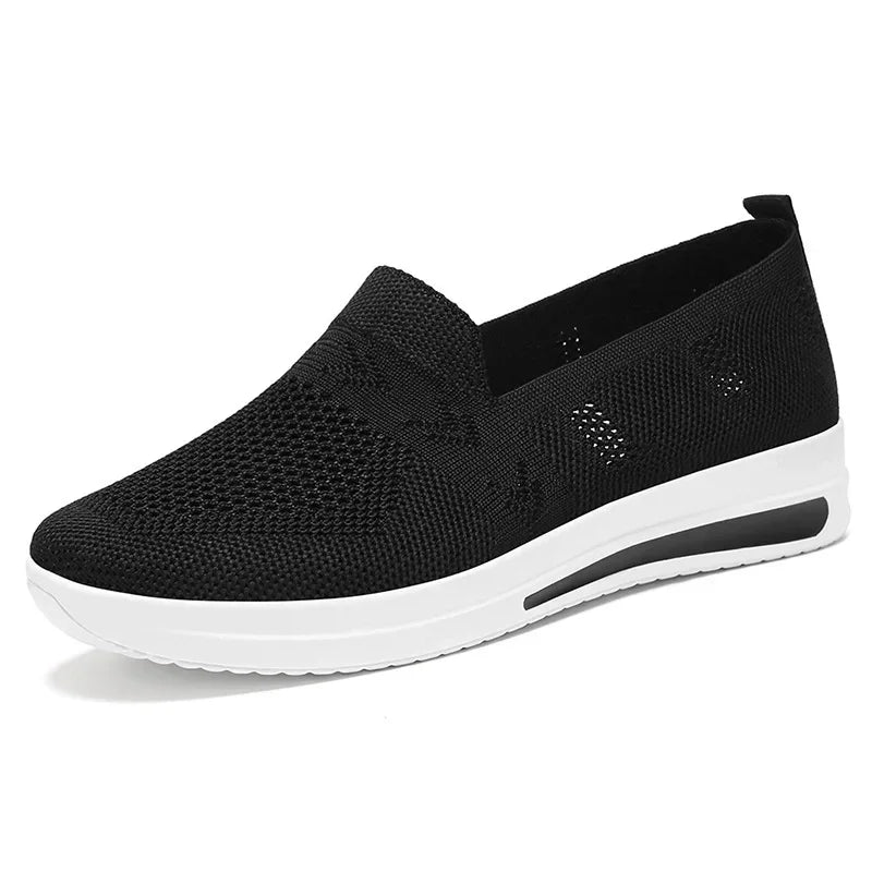 Ett par vita, andningsbara kvinnors sneakers. Mångsidiga och bekväma skor för vår och sommar.