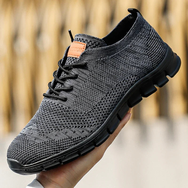 Detaljbild av en lätt herr sneaker i grått, visar andningsbart material och flexibel design för komfort.