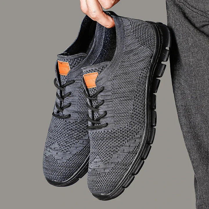 Ett par grå, lätta herr sneakers med modern design, utmärkta som komfortskor för promenader.