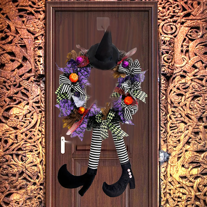 Spöklik Halloween dörrkrans med häxben som sticker ut, perfekt för ett festligt välkomnande.