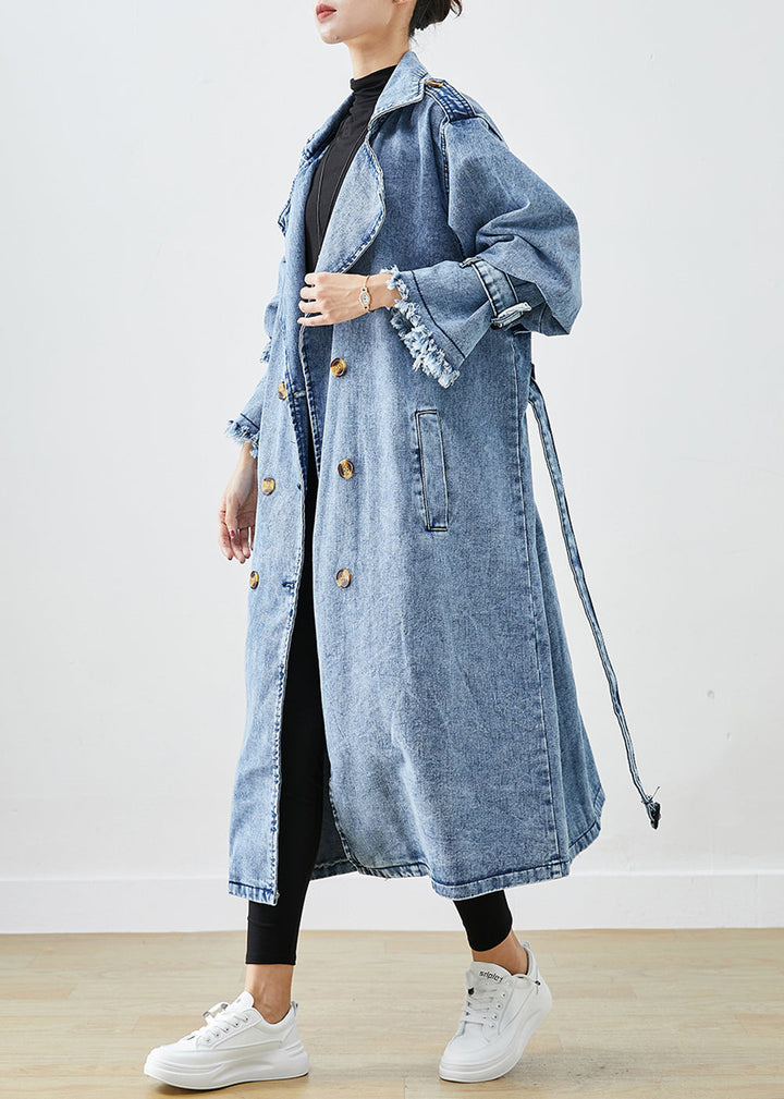 Stilren kvinnors trenchcoat i denimstil. Ljusblå dubbelknäppt kappa för vår och höst.