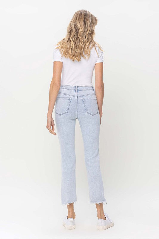 Modell bär ljusa raka damjeans med hög midja, perfekt för våren
