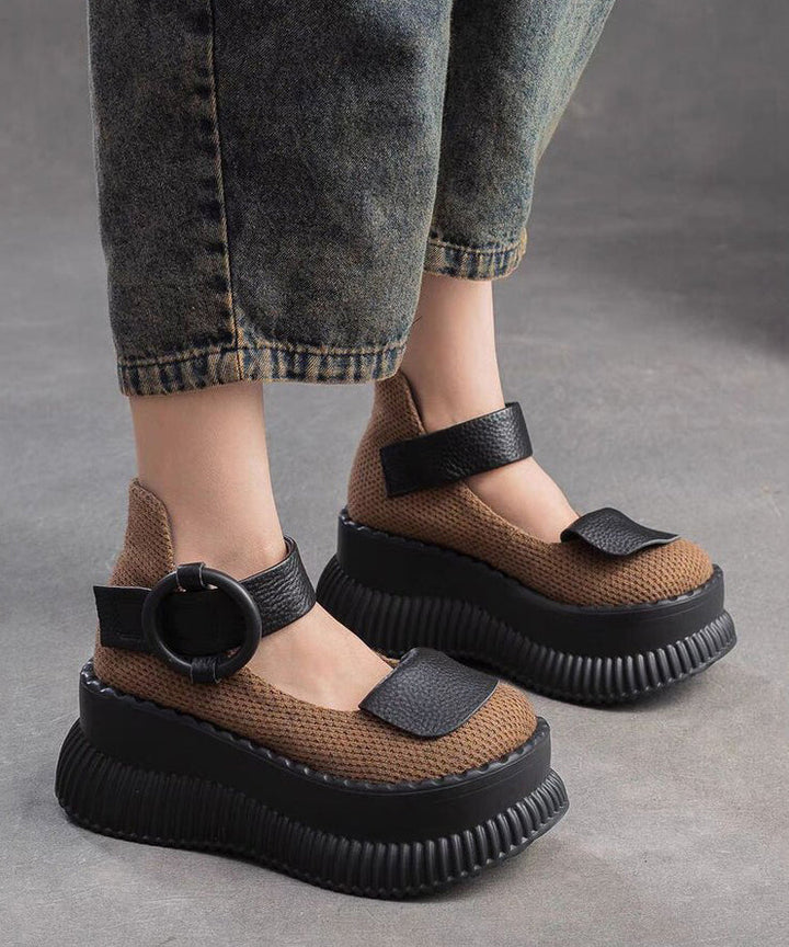 Närbild på en brun plattform loafer för dam med metallspänne, visar textur och snygg design.