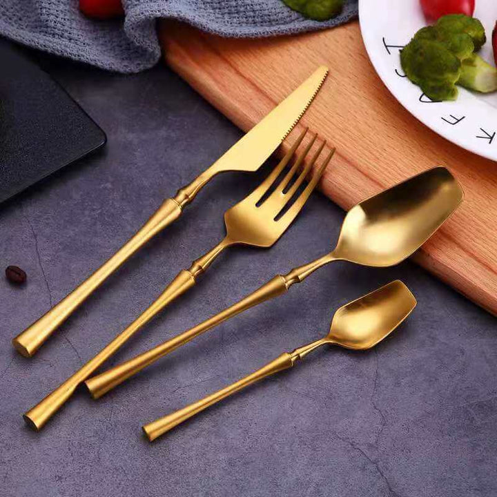 Venedig Royal Design bestickssats i guld mot en mörk bakgrund, elegant dukningsdetalj.