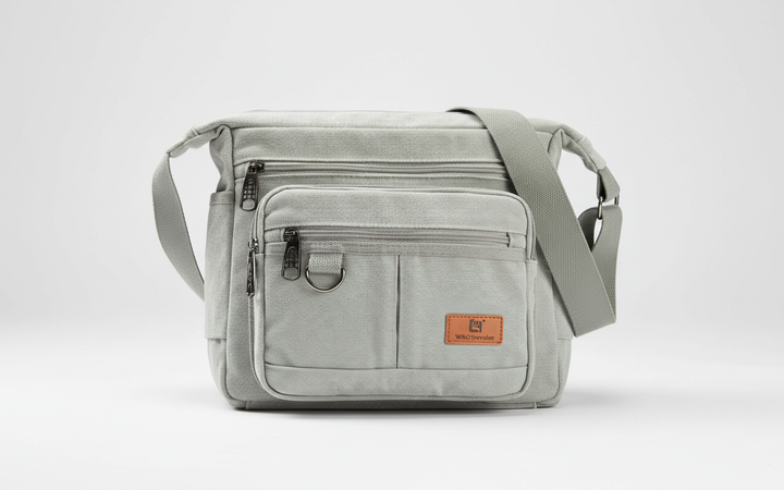 Person bär en olivgrön canvas messengerbag. Mångsidig axelväska med RFID-skydd för stilmedvetna resenärer.