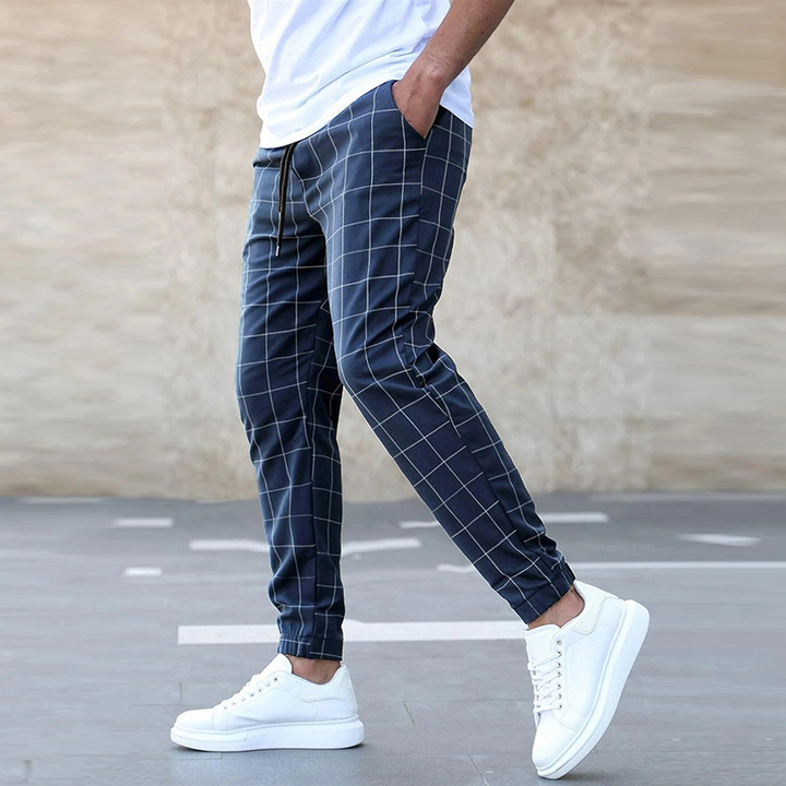 Man bär stilfulla rutiga joggingbyxor för herr, visar bekvämlighet och casual mode. Ideala fritidsbyxor.