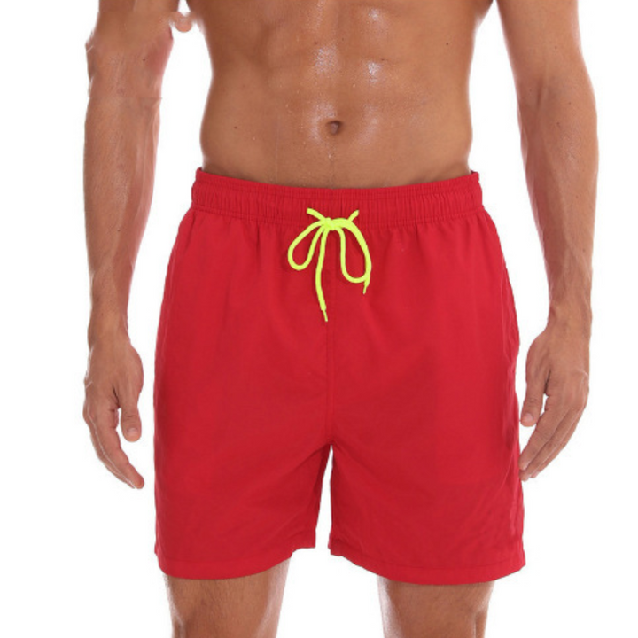 Herrbadshorts i rött för sommaren. Snabbtorkande material, utmärkt för pool och strand.