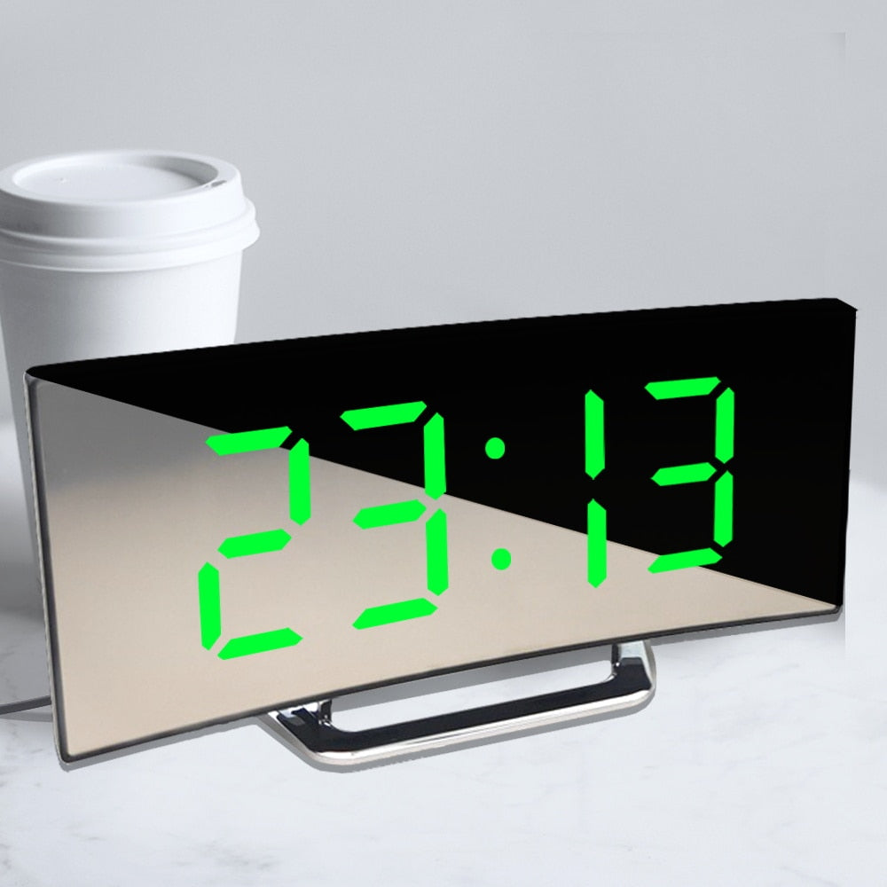 Närbild av en modern digital väckarklocka med LED-display som visar tid och temperatur, spegelfinish.