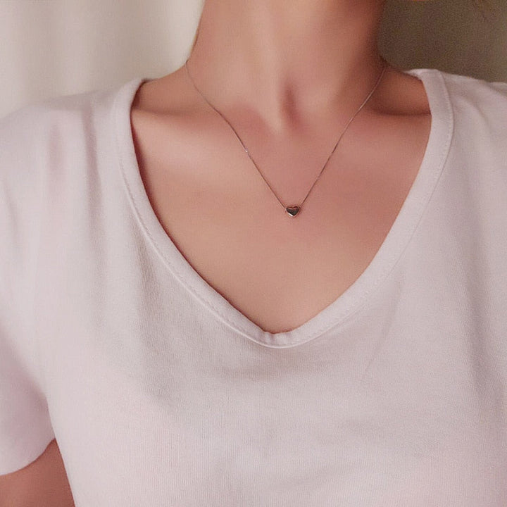 Tunt minimalistiskt silverhalsband med litet elegant hjärta. Modernt kärlekssmycke för kvinnor.