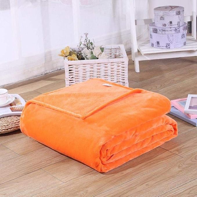 En mysig läshörna med en multifärgad korallfleece filt och böcker.