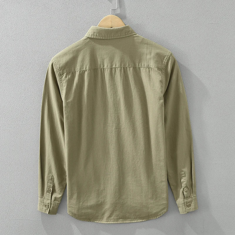 Detaljbild på mjukt tyg av en khaki herrskjorta casual, visar textur och kvalitet.