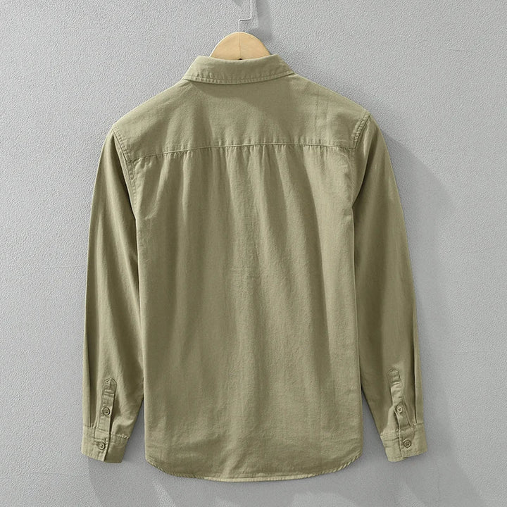 Detaljbild på mjukt tyg av en khaki herrskjorta casual, visar textur och kvalitet.