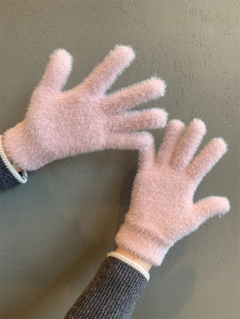 Kvinna bär varma, bekväma vinterhandskar. Trendiga damvantar som är en snygg accessoar för vintern.