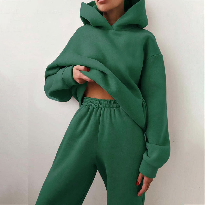 Modell visar ett komplett dam jogging set, stilfullt och bekvämt med matchande hoodie och byxor.