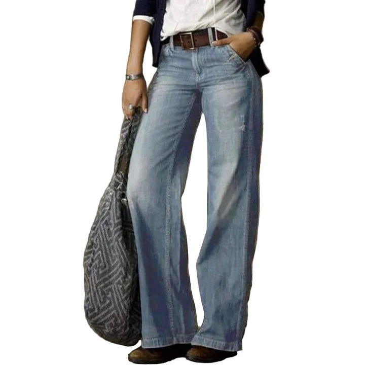 Modell bär blå vida vintage damjeans med hög midja, framifrån, för en bekväm casual stil.
