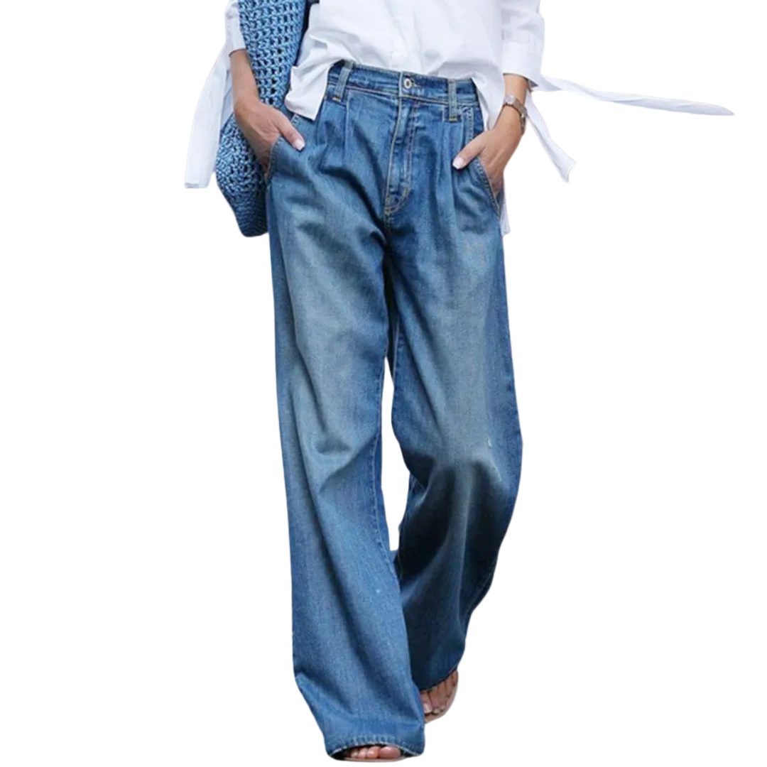 Modell bär blå vidskurna jeans med hög midja, matchade med en vit topp, för en avslappnad men stilren look.