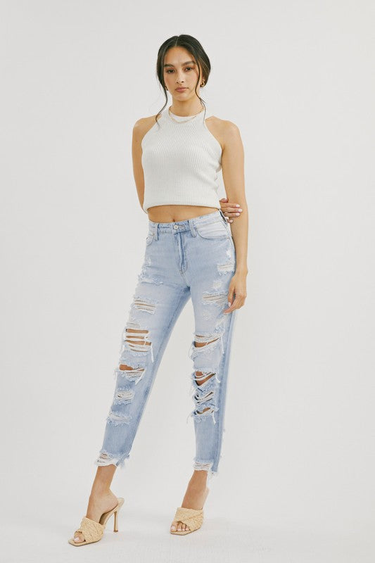 Närbild av ljus denim högmidjade jeans med distressade detaljer för kvinnor, fokus på tyg och textur. Trendiga kvinnokläder.
