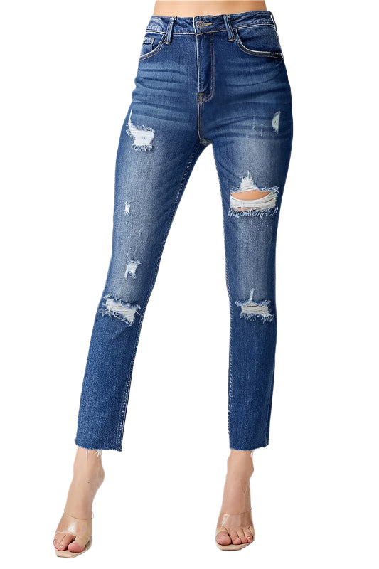 Modell bär mörka, högmidjade skinny jeans för dam med avslappnad passform och diskreta slitningar.