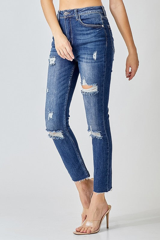Närbild på textur av slitna högmidjade skinny jeans för dam, bomullsmix, mörk denim, trendiga vårkläder.