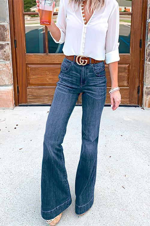 Närbild av ljusblå distressed flared jeans med märkta detaljer, perfekt för mode och sommarstil.