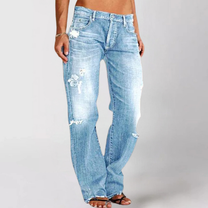 Långskott av kvinnors stretchjeans med utsvängda ben i blå nyans, vardagsjeans.