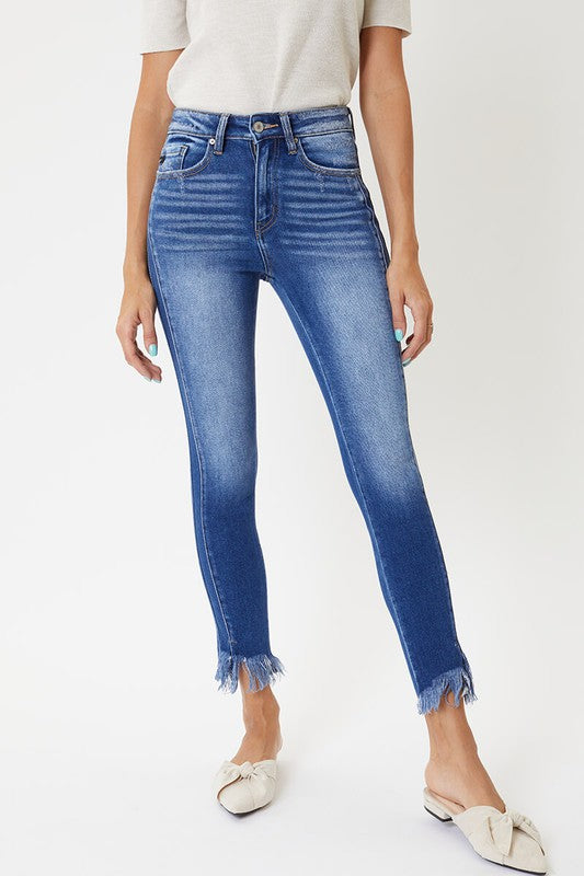 Närbild på midjan av högmidjade skinny jeans med synliga sömmar och knappdetalj, perfekt för mode.