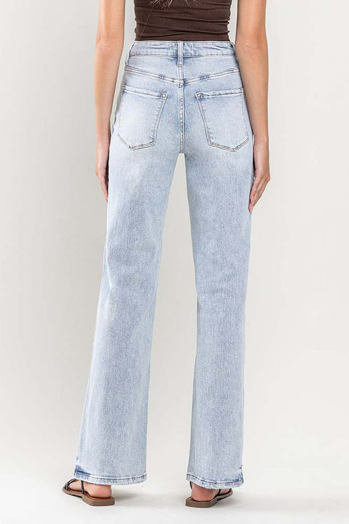 Närbild av benen på ett par flared jeans för kvinnor med superhög midja, i vintagestil denim för vardagsbruk.