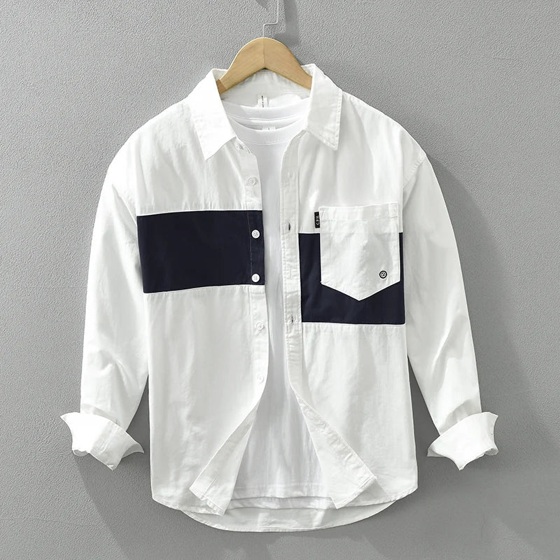 Man bär avslappnad patchwork herrskjorta, kombinerad med moderna byxor för en stilren fritidslook.