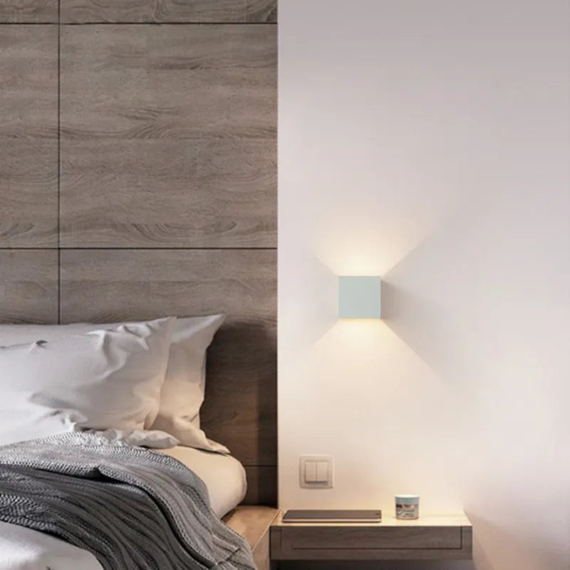 Minimalistisk vägglampa med kubdesign och rörelsesensor. Modern LED-armatur som skapar stämningsfullt ljus.