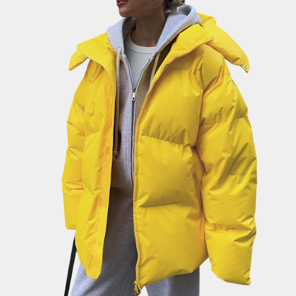 Mode dam vinterjacka puffer, rymlig och varm. En modern jacka för kvinnorsytterkläder i kyligt klimat.