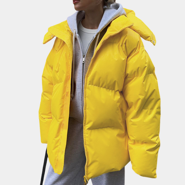 Mode dam vinterjacka puffer, rymlig och varm. En modern jacka för kvinnorsytterkläder i kyligt klimat.