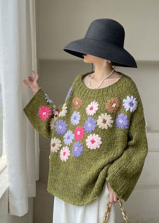 Trendig damtröja med intrikata broderade blommor, stickad i mjukt garn för en vardagslook.